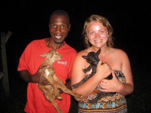 volunteers holding baby goats in Uganda