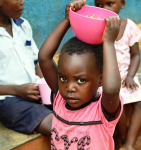 small ugandan children carrying food