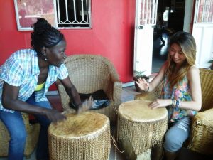 Volunteers learning to drum in Uganda