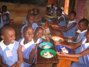 Ugandan school students eating a hot meal of posho and beans