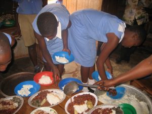Ugandan school children serving lunch at school
