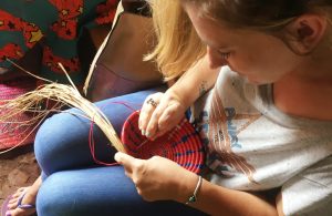 volunteer learning to weave baskets in uganda